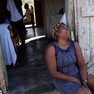 Image: A relative cries before the funeral of Anne Dit Trozitha Zamore, who died during Hurricane Matthew, in Chantal, Haiti