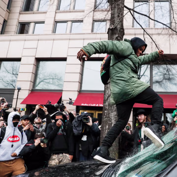 Image: A protester kicks in a windshield during a demonstration in Washington, D.C on Jan. 20 after the inauguration of President Donald Trump.
