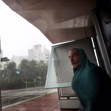 Image: A homeless man takes shelter at a bus stop in Miami Beach on Sept. 10.