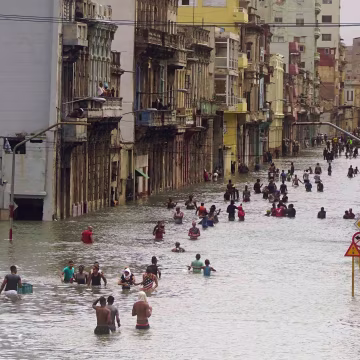 Image: People move through flooded streets in Havana after the passage of Hurricane Irma