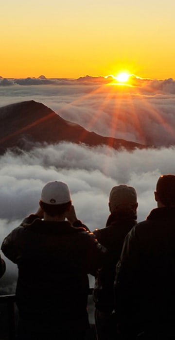 Image: Visitors watch the sun rise at 10,000 feet in Haleakala National Park in Maui, Hawaii.
