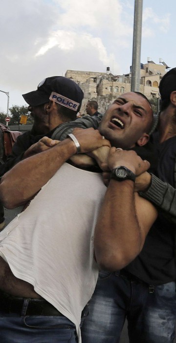 Image: An undercover Israeli policeman detains a Palestinian protester during clashes in Jerusalem's Old City