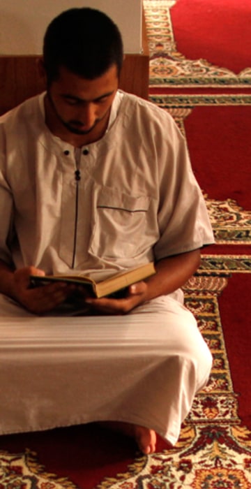 Image: A Muslim man reads the Koran during the first day of Ramadan at a mosque in Estepona