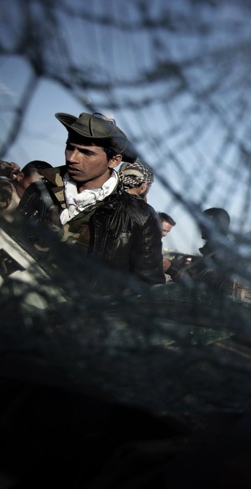 Image: Libyan rebel fighters look inside of a c