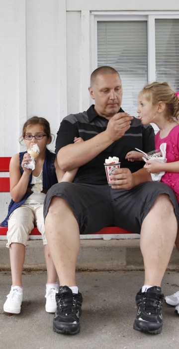 Carl Poff feeds his daughter Joselyn, 4, a bite of ice cream outside Rita's Italian Ice in Easton, Pa.
