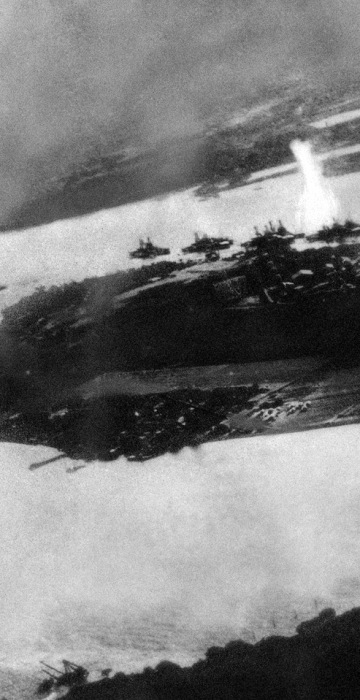 Believed to be the first bomb dropped on Pearl Harbor, Hawaii in the sneak-attack on Dec. 7, 1941, this picture was found torn to pieces at Yokusuka Base by photographer's mate 2/C Martin J. Shemanski of Plymouth, Pa. One Japanese plane is shown pulling out of a dive near bomb eruption (center) and another the air at upper right. (AP Photo)