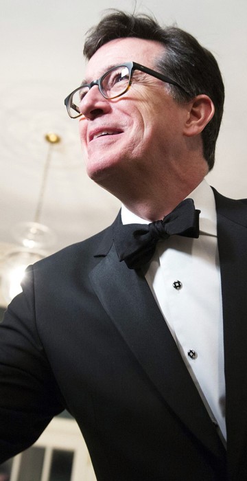 Image: Comedian Stephen Colbert greets a reporter as he arrives for the State Dinner being held for French President Francois Hollande at the White House