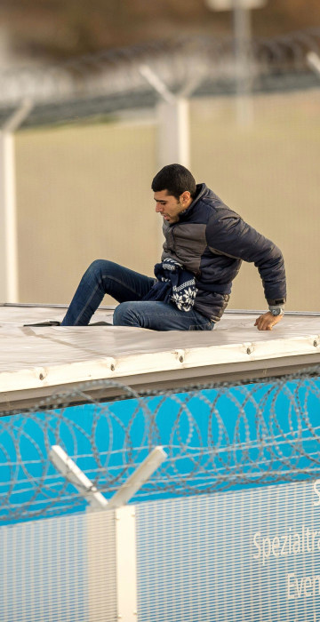 Image: A migrant or refugee enters the trailer of a truck