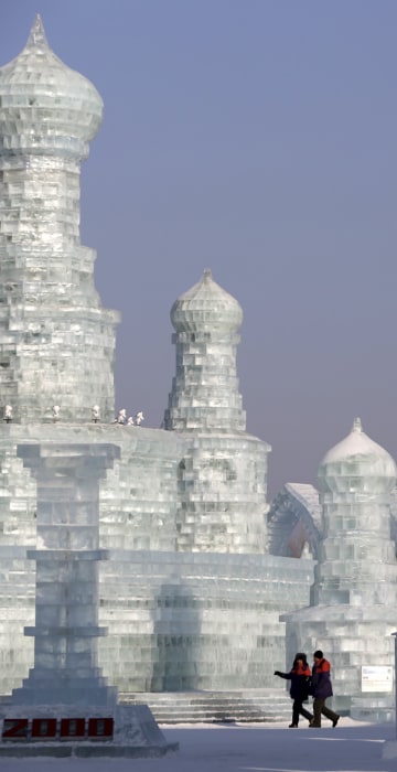 Image: People look around ice sculptures ahead of the Harbin International Ice and Snow Festival in the northern city of Harbin