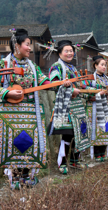 Image: Ethnic Dong women wearing traditional costumes, hold \"pipas\", a traditional instrument