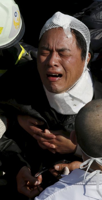 Image: A relative cries after his family member was confirmed dead at a 17-storey apartment building that collapsed after an earthquake hit Tainan, southern Taiwan