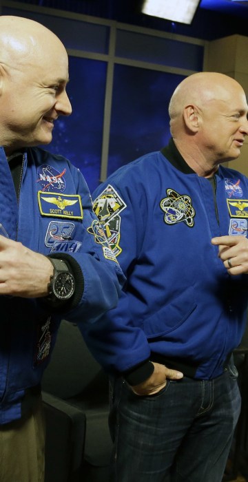 NASA astronaut Scott Kelly, left, and his identical twin Mark, a retired NASA astronaut, stand together before a news conference in Houston. Scott Kelly set a U.S. record with his 340-day mission to the International Space Station. 