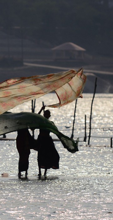 Image: Indian women dry their saris after taking a dip at Sangam