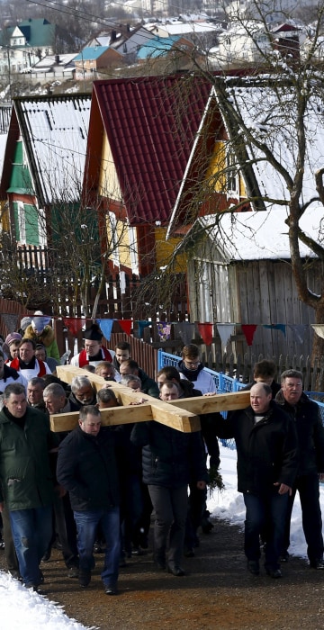 Image: Belarussian Catholics carry a wooden cross as they take part in a procession celebrating Palm Sunday in the town of Oshmiany