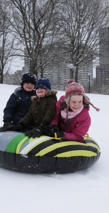 Image: Siblings Leo, Max and Zoe Zavrachy ride down a snow covered hill on Boston Common during a snow storm on the second day of spring in Boston