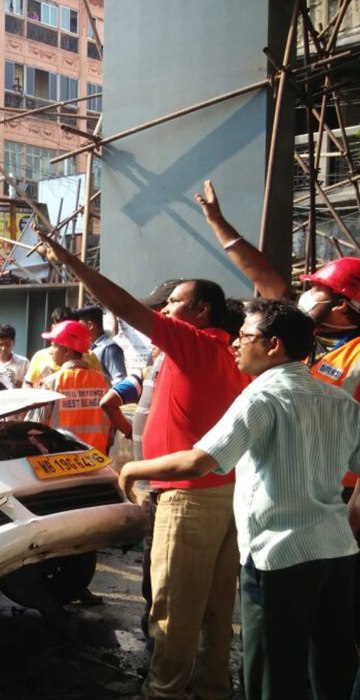 Image: Locals and rescue workers clear the rubble of a partially collapsed overpass