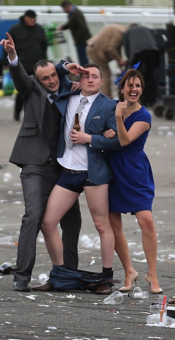 Image: A man plays to the cameras as racegoers make their way home at the end of Ladies Day