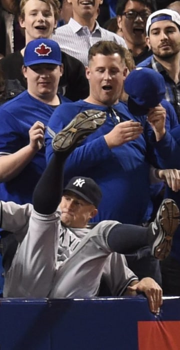 Image: New York Yankees' Brett Gardner falls into the stands after catching a foul ball
