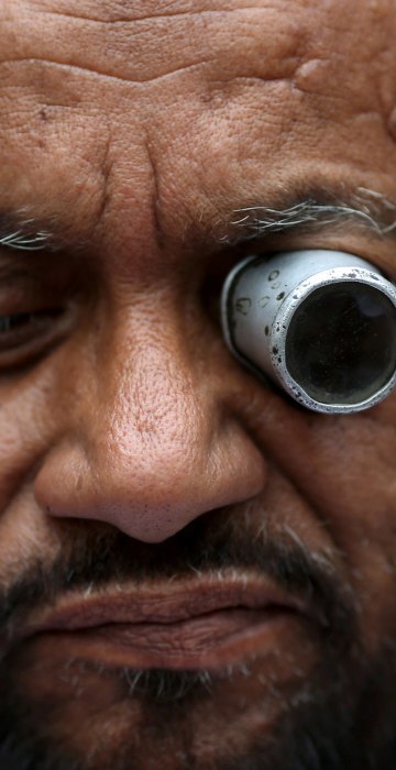 Image: A man repairs a watch at a roadside shop in the old quarters of Delhi