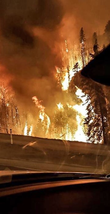 Fires burn at the edge of the road as evacuating motorists flee Fort McMurray on May 3. 
There were long lines on highways out of the city of 61,000 people as frantic residents fled the blaze, and oilsands work camps were pressed into service as emergency shelters.