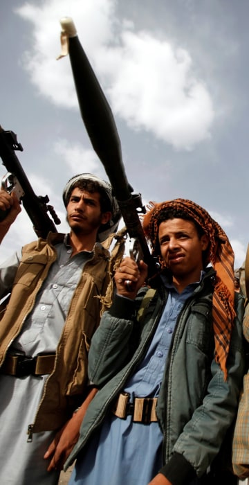 Image: Houthi fighters carry their weapons as they attend a tribal gathering in Sanaa