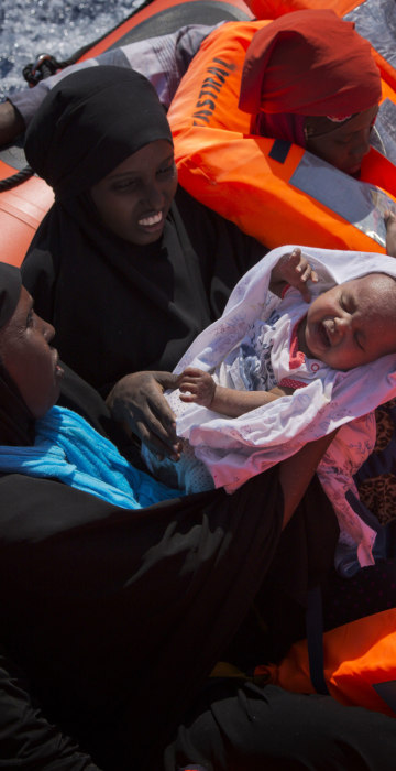 Image: Migrant women from Nigeria, one of them holding a baby, are rescued by emergency teams