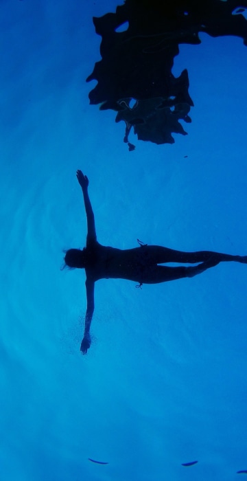 Image: a woman floats in a swimming pool during a summer day in Madrid