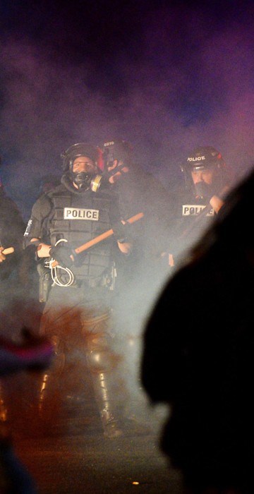 Image: Officers stand in formation in front of protesters in Charlotte