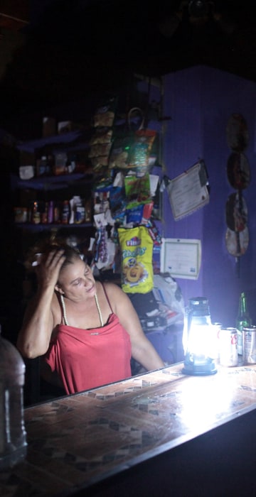 Image: Flor Dalisa Contreras talks with Virginia Rivas at a coffee shop during a power outage that affected several areas in the country, in San Juan