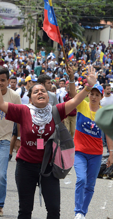 Image: Demonstrators shout slogans in front of Venezuelan National Guard members during a rally demanding a referendum to remove Venezuela's President Maduro in San Cristobal