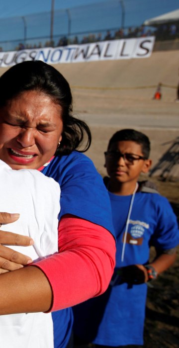 Image: Relatives separated by deportation and immigration hug at the border during a brief reunification meeting at the banks of the Rio Bravo, a natural border between U.S. and Mexico