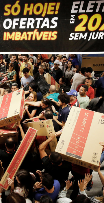 Image: Shoppers reach out for television sets as they compete to purchase retail items on Black Friday at a store in Sao Paulo