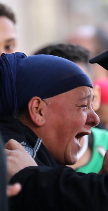 Image: A relative of one of the blast victims screams at a police officer in front of St. Mark's Coptic Orthodox Cathedral after an explosion inside the cathedral in Cairo