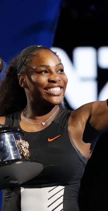 Image: United States' Serena Williams holds her trophy after defeating her sister Venus