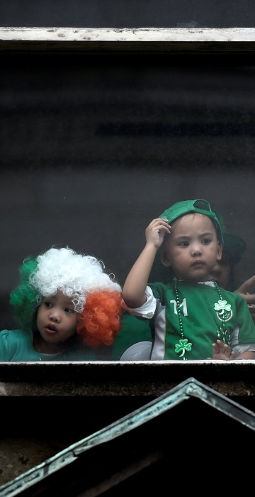 Image: Children watch the St. Patrick's day parade from a window in Dublin