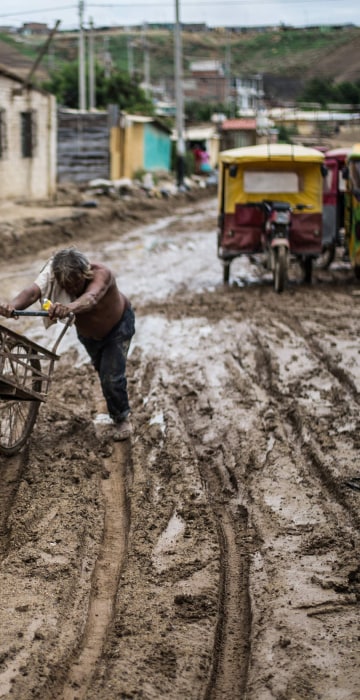 Image: A local resident pushes his cart through the mud after the flooding caused by recent rains, in the province of Paita in Piura, northern Peru, on March 24, 2017.