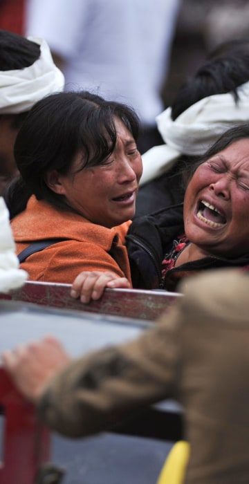 Image: Women become emotional at the site of the landslide on June 25.