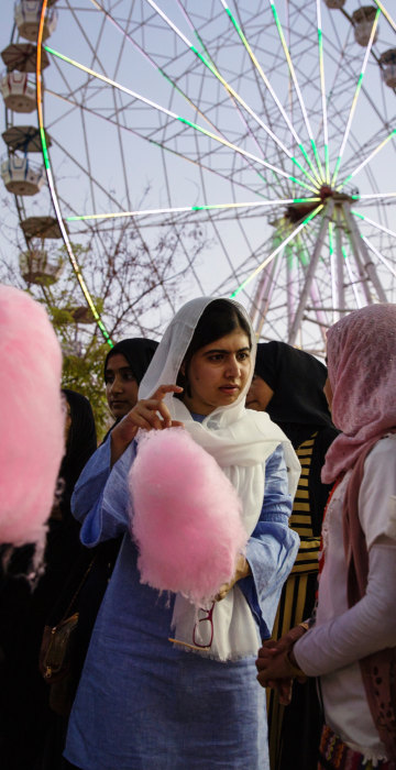 Image: Malala Yousafzai visits an amusement park and eats cotton candy with children displaced by ISIS conflict