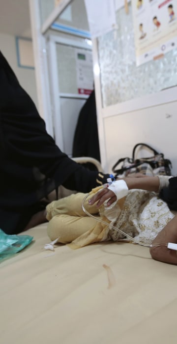 Image: A girl is treated for suspected cholera infection at a hospital in Sanaa