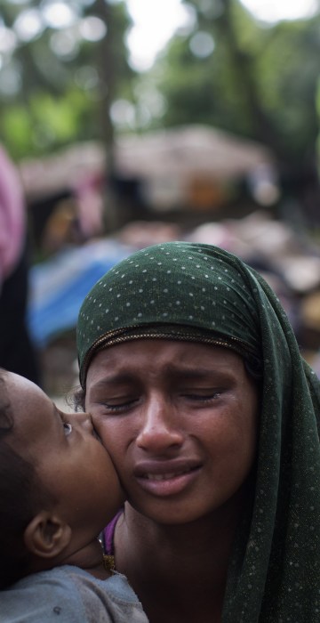 Image: A Rohingya Muslim kisses his mother as they rest after having crossed over from Myanma