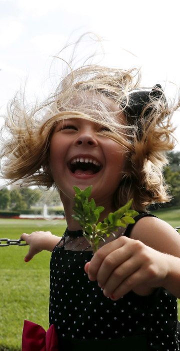 Image: Brooke Fiddes, 5, and her brother Carter Fiddes, 9, both from Charlotte, N.C., react from the rotor wash of Marine One