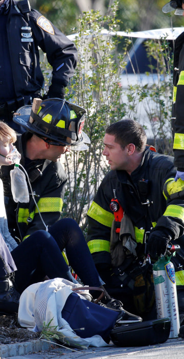 Image: A woman is aided by first responders after sustaining injury on a bike path in lower Manhattan in New York