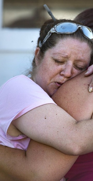 Image: Carrie Matula embraces a woman after a fatal shooting