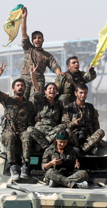 Image: Syrian Democratic Forces (SDF) fighters ride atop of military vehicles as they celebrate victory in Raqqa