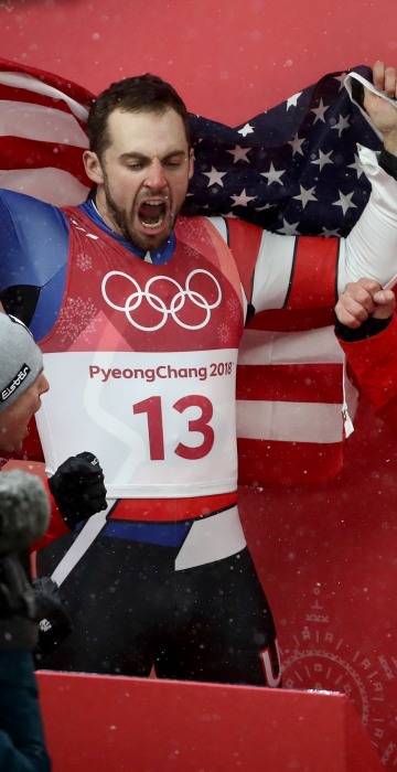Chris Mazdzer (silver) of the U.S., David Gleirscher (gold) of Austria and Johannes Ludwig (bronze) of Germany celebrate following the luge men's singles competition on Feb. 11.
