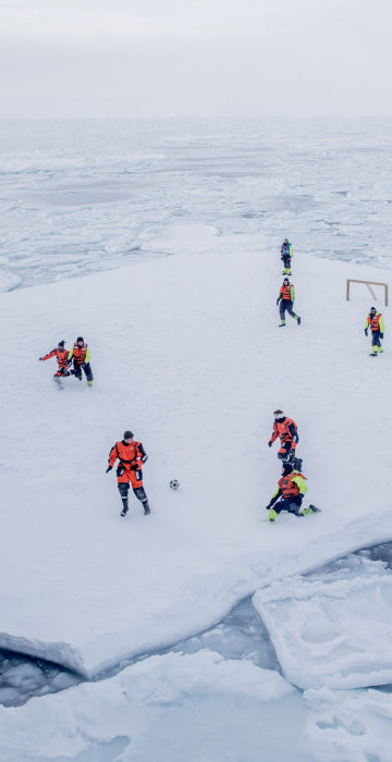 Image: KV Svalbard's crew play soccer as they are protected from polar bears by armed guards in the arctic environment in the sea around Greenland