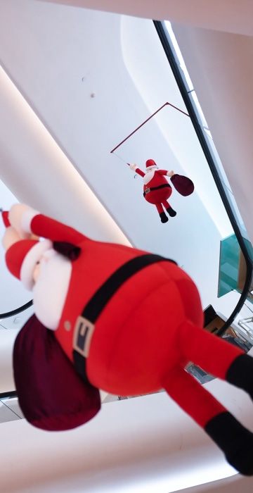 Image: A man looks at a dangling Santa Claus display at a mall in Bangkok on Dec. 25.
