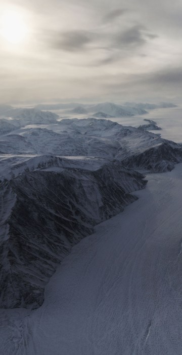 A section of glacier flows between ridges on Ellesmere Island, Canada.