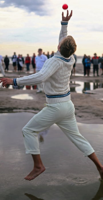 Image: A player participates in the annual Brambles Sandbank cricket match at low tide in the Solent