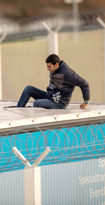 Image: A migrant or refugee enters the trailer of a truck